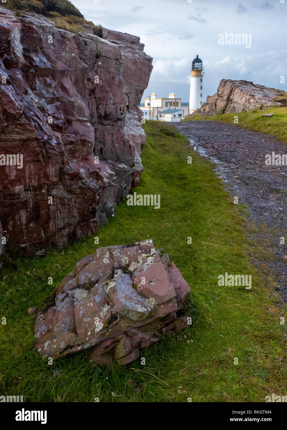 Felsen und und ein schotterweg Richtung Rua Reidh Leuchtturm auf einer sonnigen und bewölkten Tag am Eingang zum Loch Ewe, Wester Ross, Schottland führenden Stockfoto