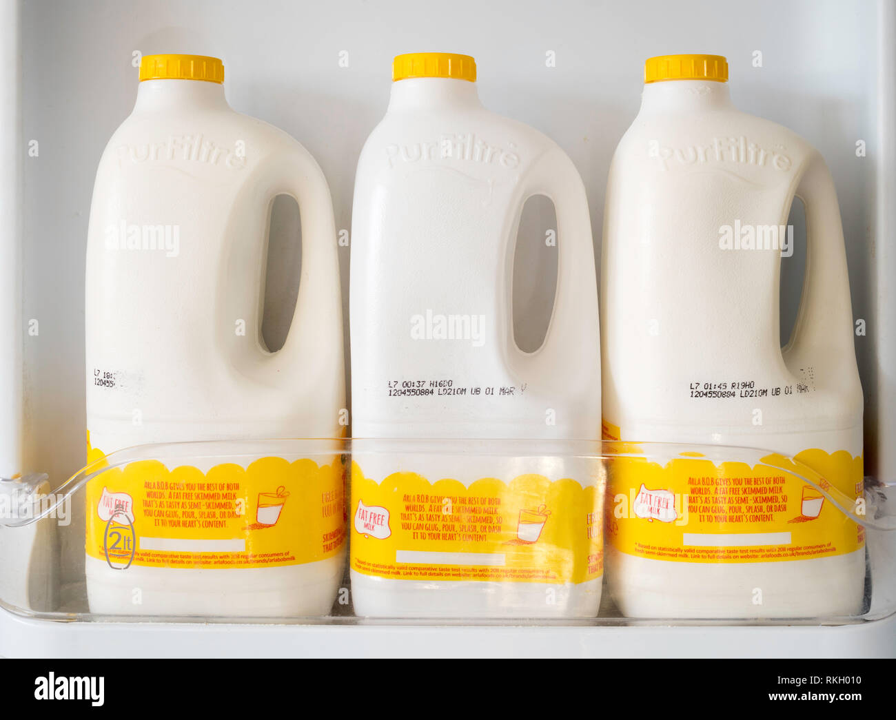 Drei Container von Arla B.O.B. fettfreie Milch im Kühlschrank Tür, England, Großbritannien Stockfoto