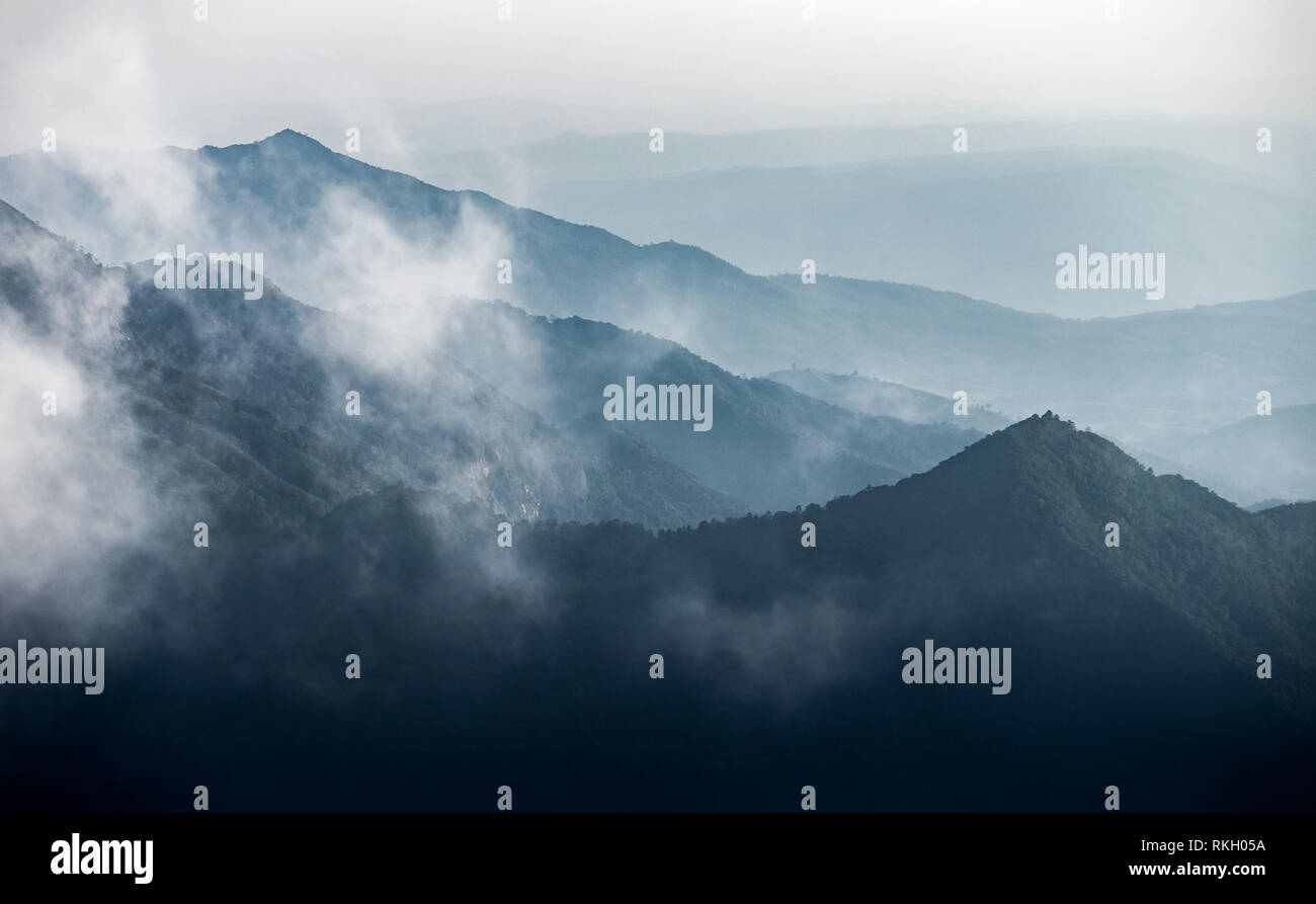 Dark Blue Mountain Range in verschiedenen Schichten der Winter von Nebel und Wolken bedeckt nach Chiangmai, Thailand regnet. Stockfoto