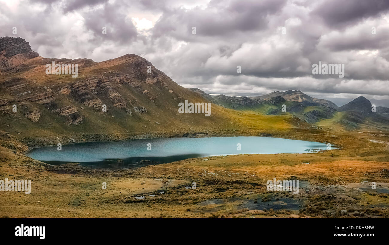 Panorama von einer grünen Lagune/See auf der Oberseite der Anden von Peru" unter einem bewölkten Dark sky Stockfoto