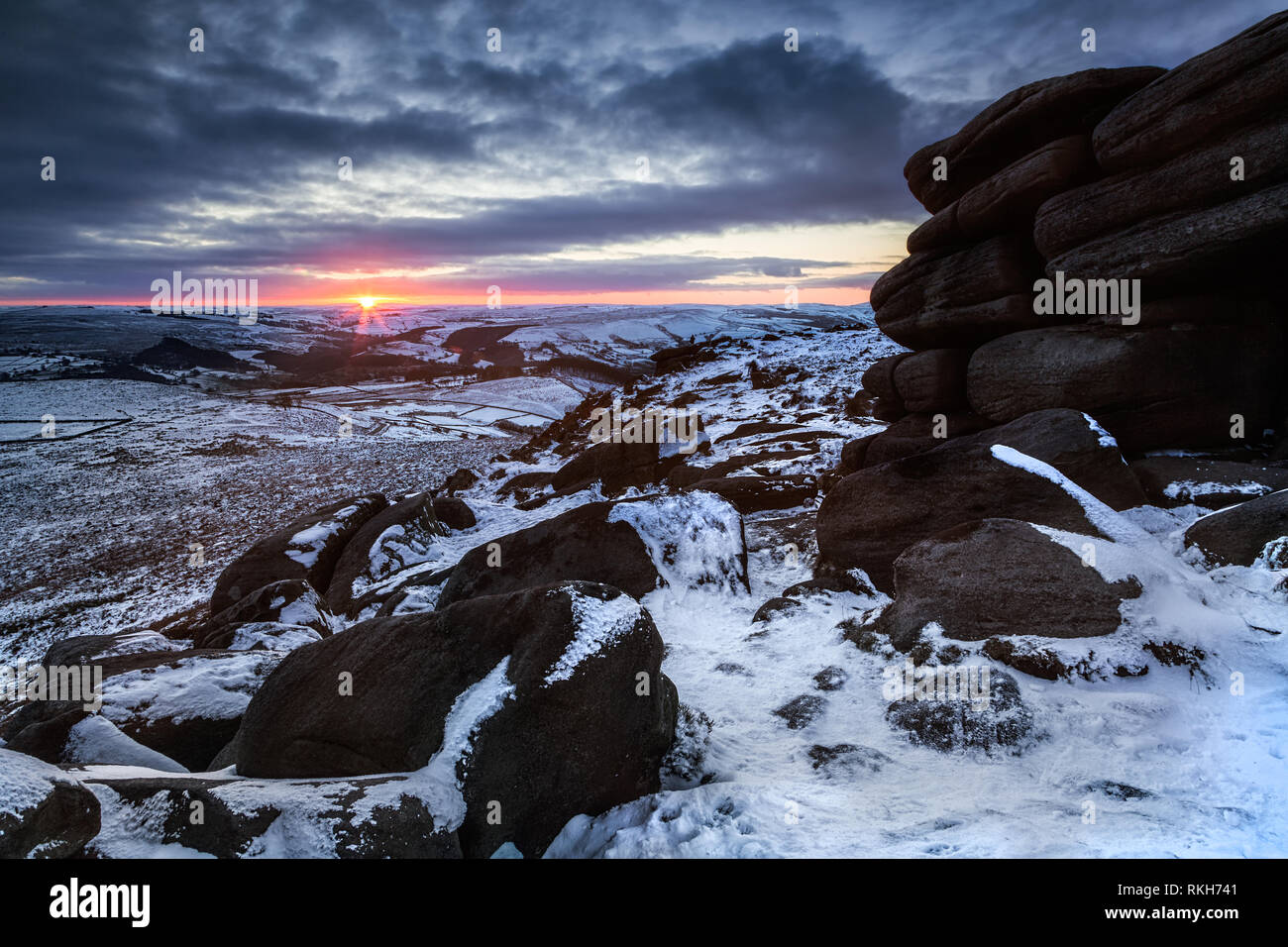 Sonnenuntergang an Higger Tor, Peak District, Derbyshire während der Schnee im Winter Stockfoto