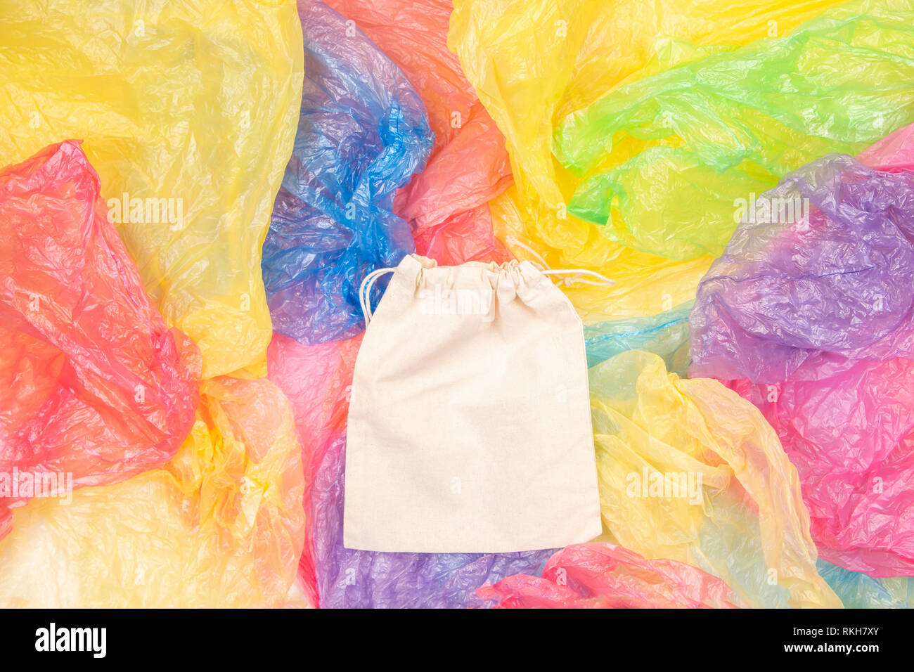 Viele bunte Plastiktüten mit einem eco-natürliche, wiederverwendbare Tasche zum Einkaufen. Null Abfall, Umweltfreundlich, Nachhaltigkeit Lebensstil, kein Plastik Konzept Stockfoto