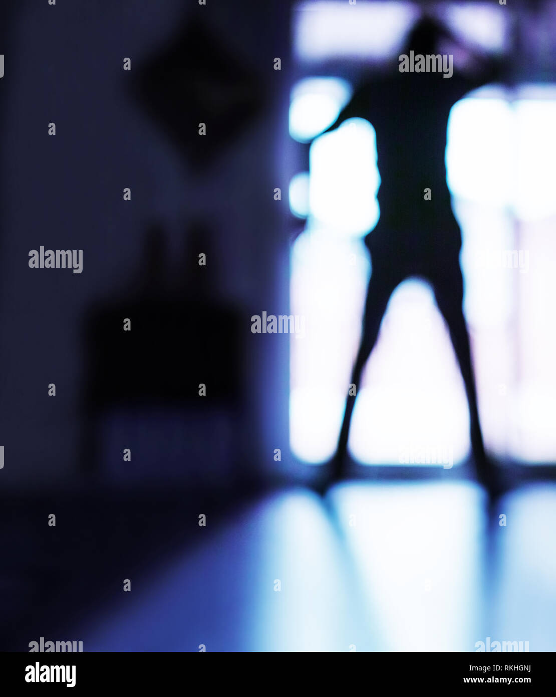 Gegen das Licht, sehen wir die Silhouette eines großen Mannes vor der Terrassentür. Ist vielleicht jemanden, der durch die Fenster oder ist ein Eindringling, der betritt. Stockfoto