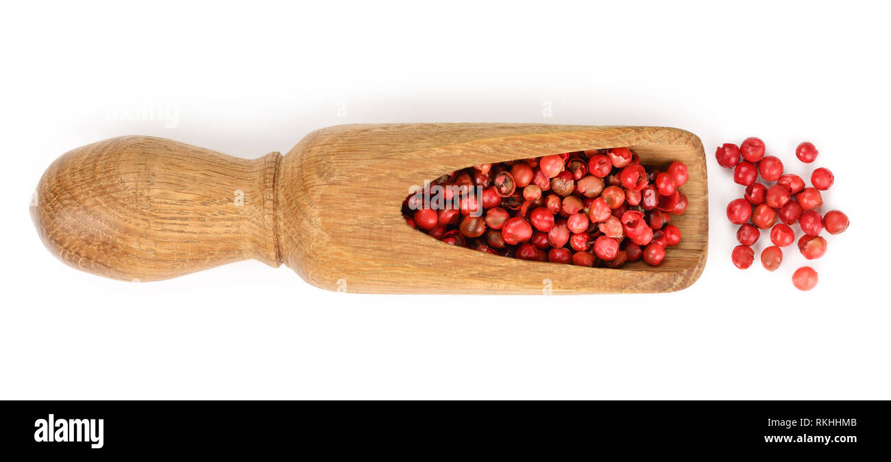 Rote Pfefferkörner Samen in Holz- Schaufel auf weißem Hintergrund. Ansicht von oben. Flach Stockfoto