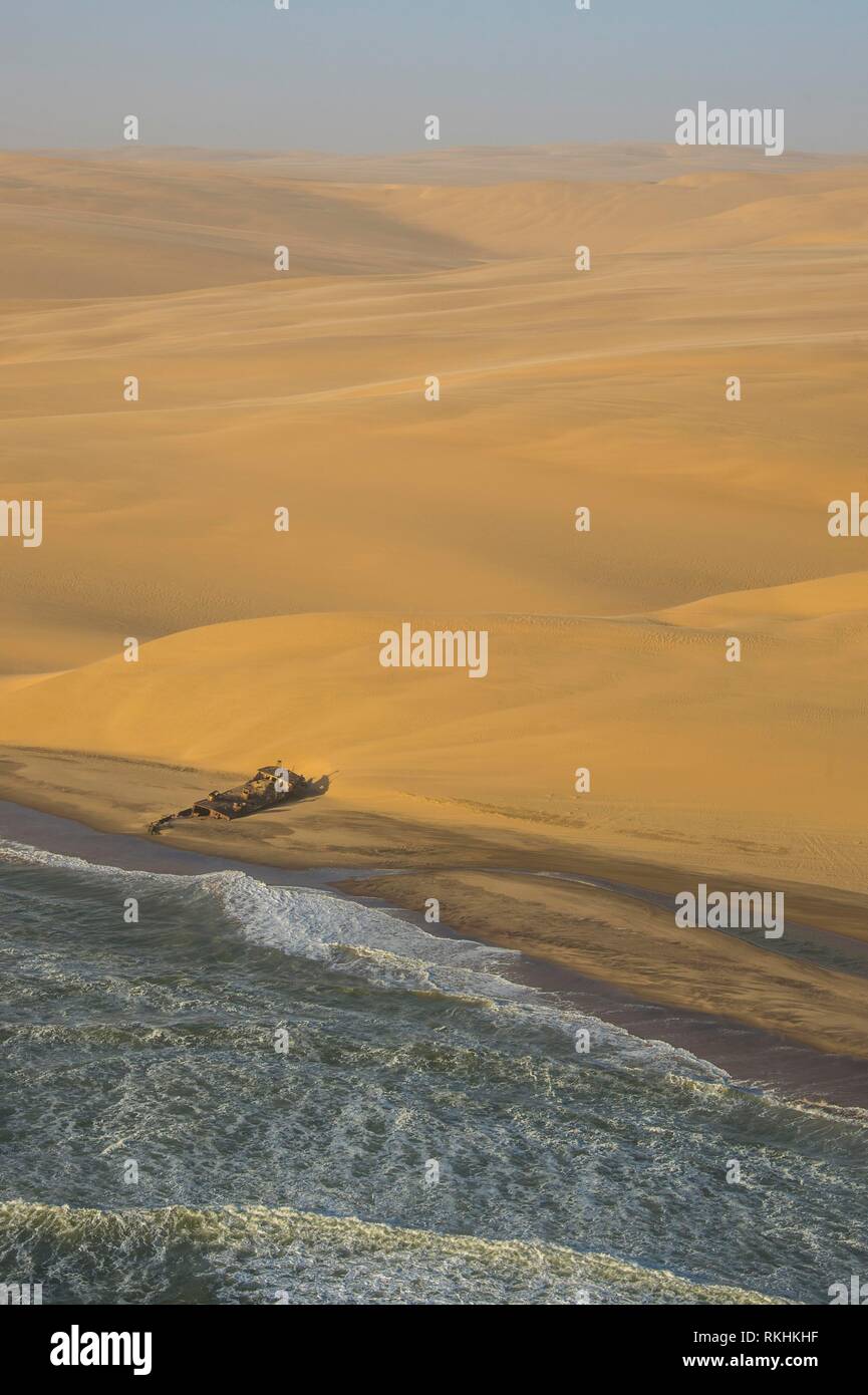 Luftaufnahme von Sanddünen mit Schiffswrack, Namib Wüste Schwimmen im Ozean, Namibia Stockfoto