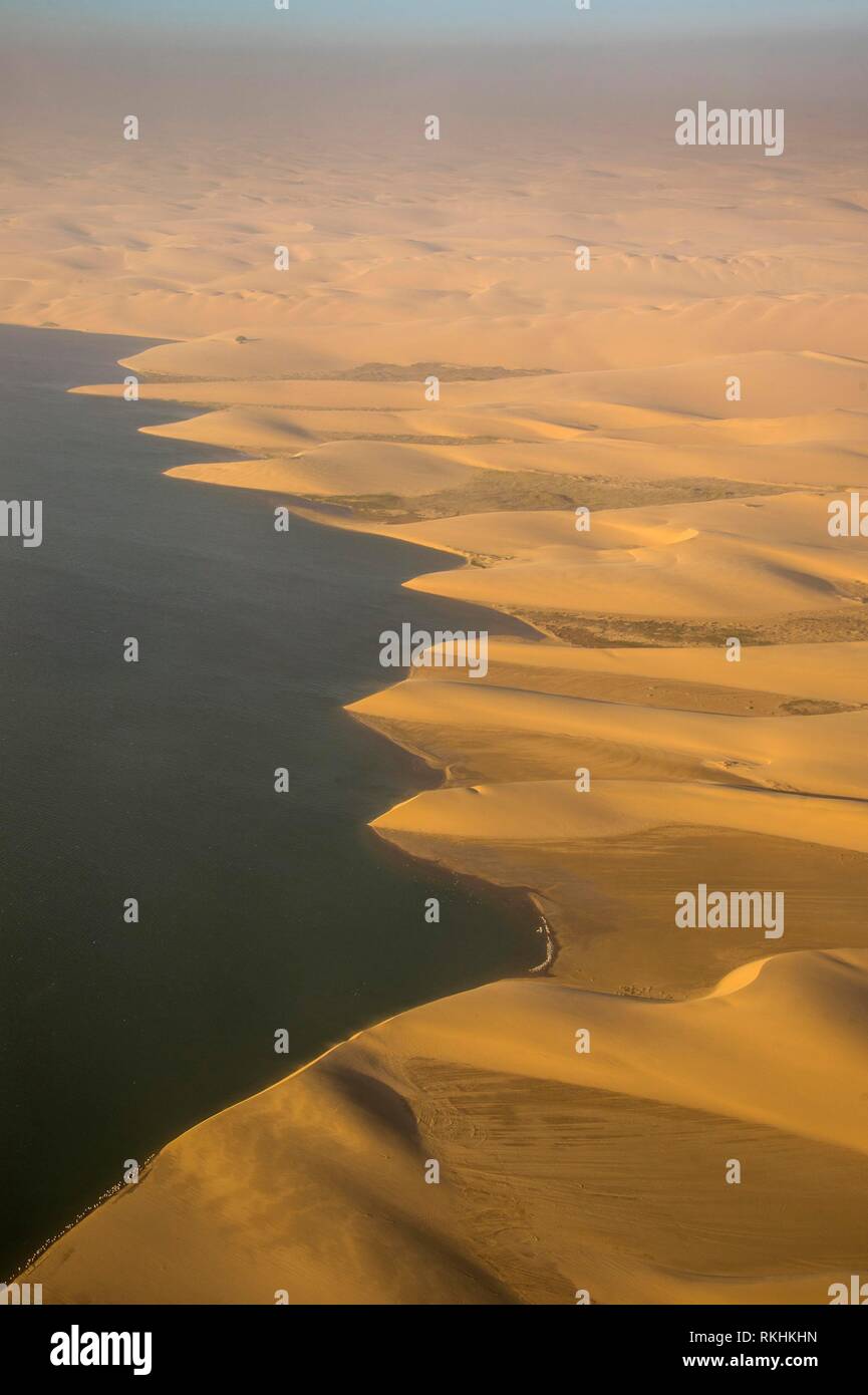 Luftaufnahme der Küstenlinie mit sandunes der Namib Wüste Schwimmen im Ozean, Namibia Stockfoto
