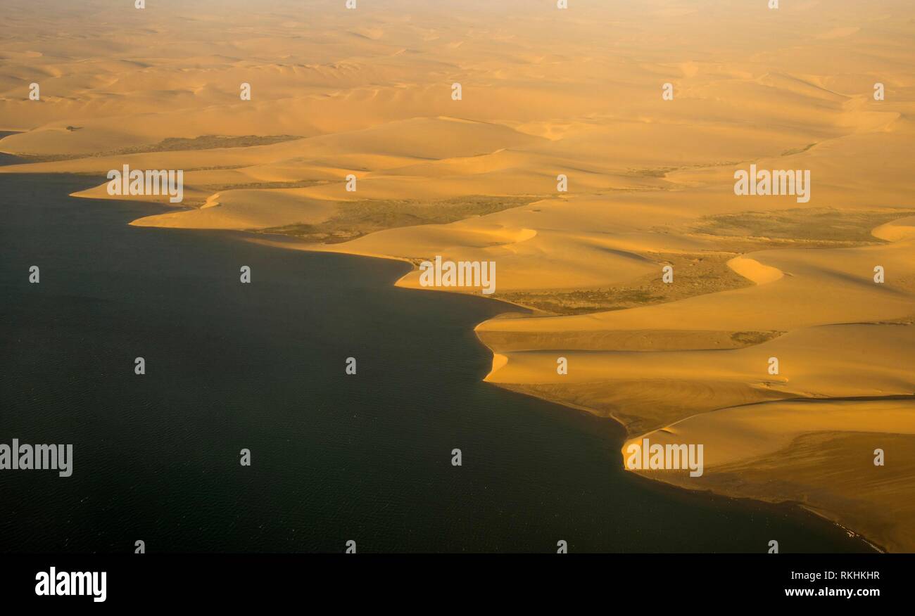 Luftaufnahme der Küstenlinie mit sandunes der Namib Wüste Schwimmen im Ozean, Namibia Stockfoto