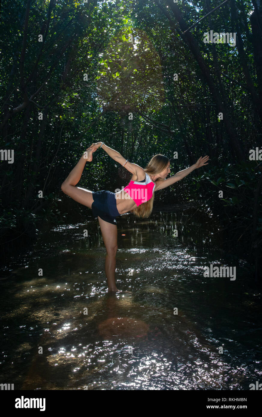 Junge Frau mit Yoga (Herr des Tanzes Pose-Natarajasana) in einer natürlichen Umgebung - Fort Lauderdale, Florida, USA Stockfoto
