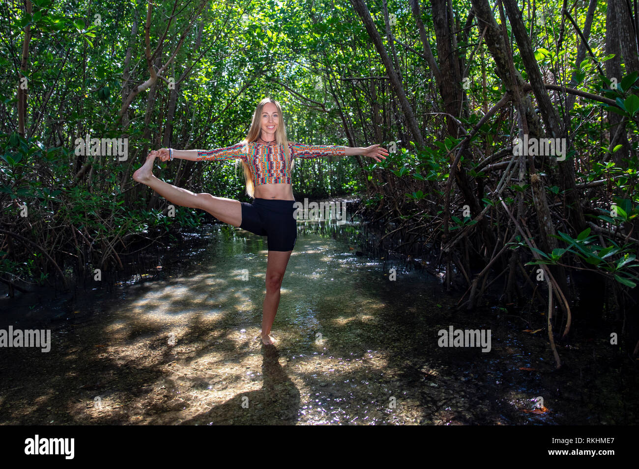 Junge Frau mit Yoga (verlängerte Hand-zu-Big-Toe Pose - Utthita Hasta Padangustasana) in einer natürlichen Umgebung - Fort Lauderdale, Florida, USA Stockfoto