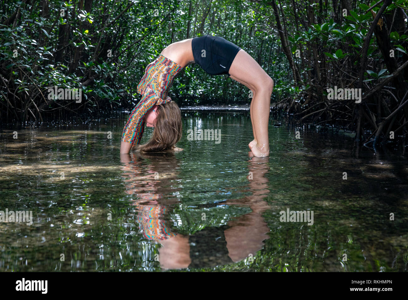 Junge Frau mit Yoga (Rad Pose-Urdhva Dhanurasana) in einer natürlichen Umgebung - Fort Lauderdale, Florida, USA Stockfoto