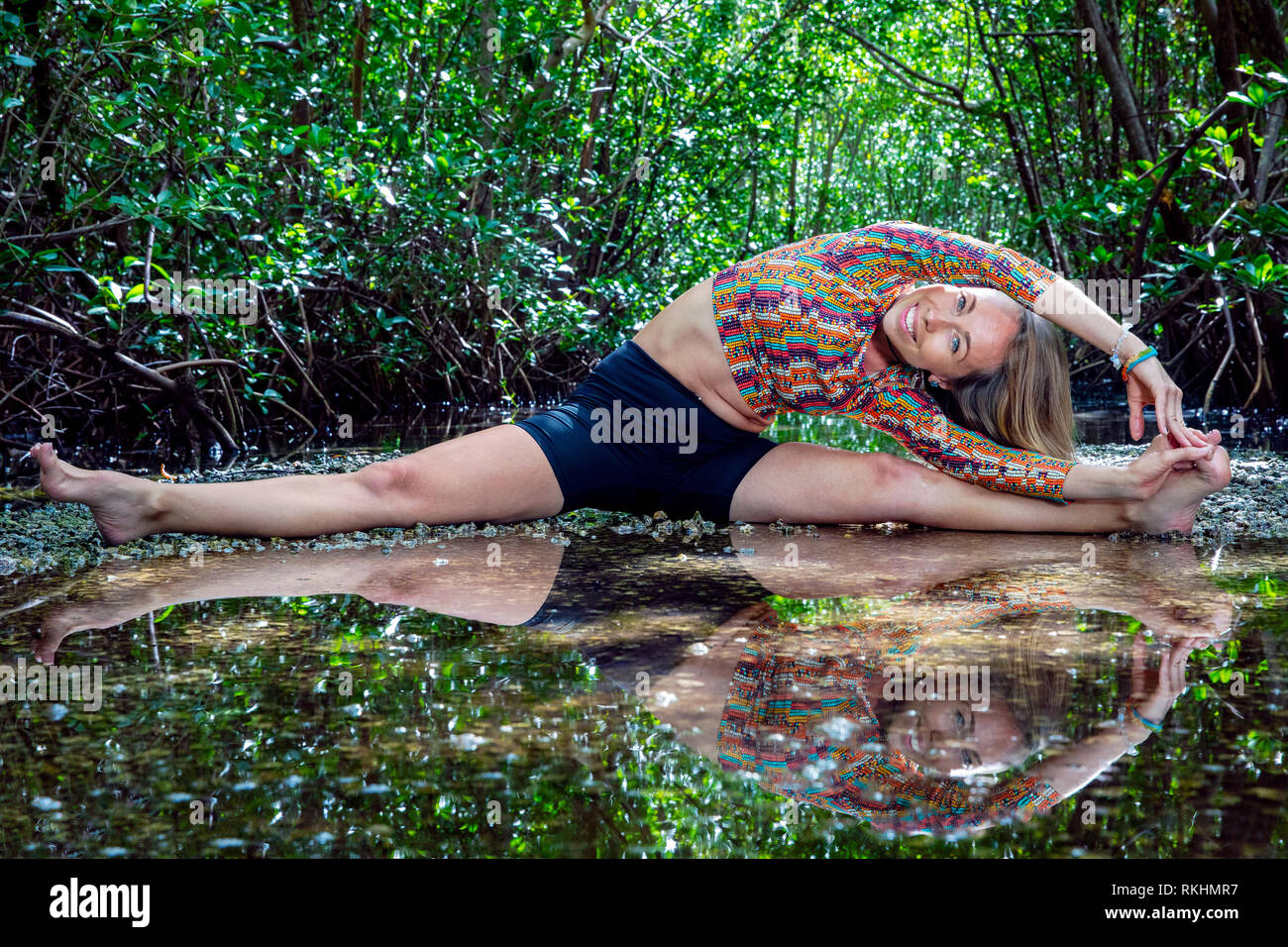 Junge Frau mit Yoga (stelzrad Split) in einer natürlichen Umgebung - Fort Lauderdale, Florida, USA Stockfoto