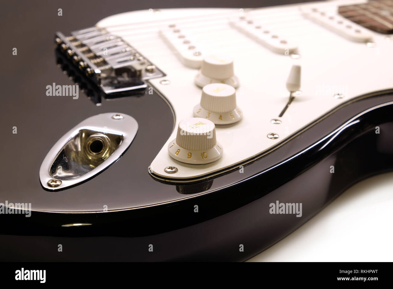 Teil der modernen elektrischen 6-saitige Gitarre Schwarz mit glänzender Oberfläche mit leeren Metall-Buchse, Buchse, Pickups und Regler auf weißen Ba isoliert Stockfoto
