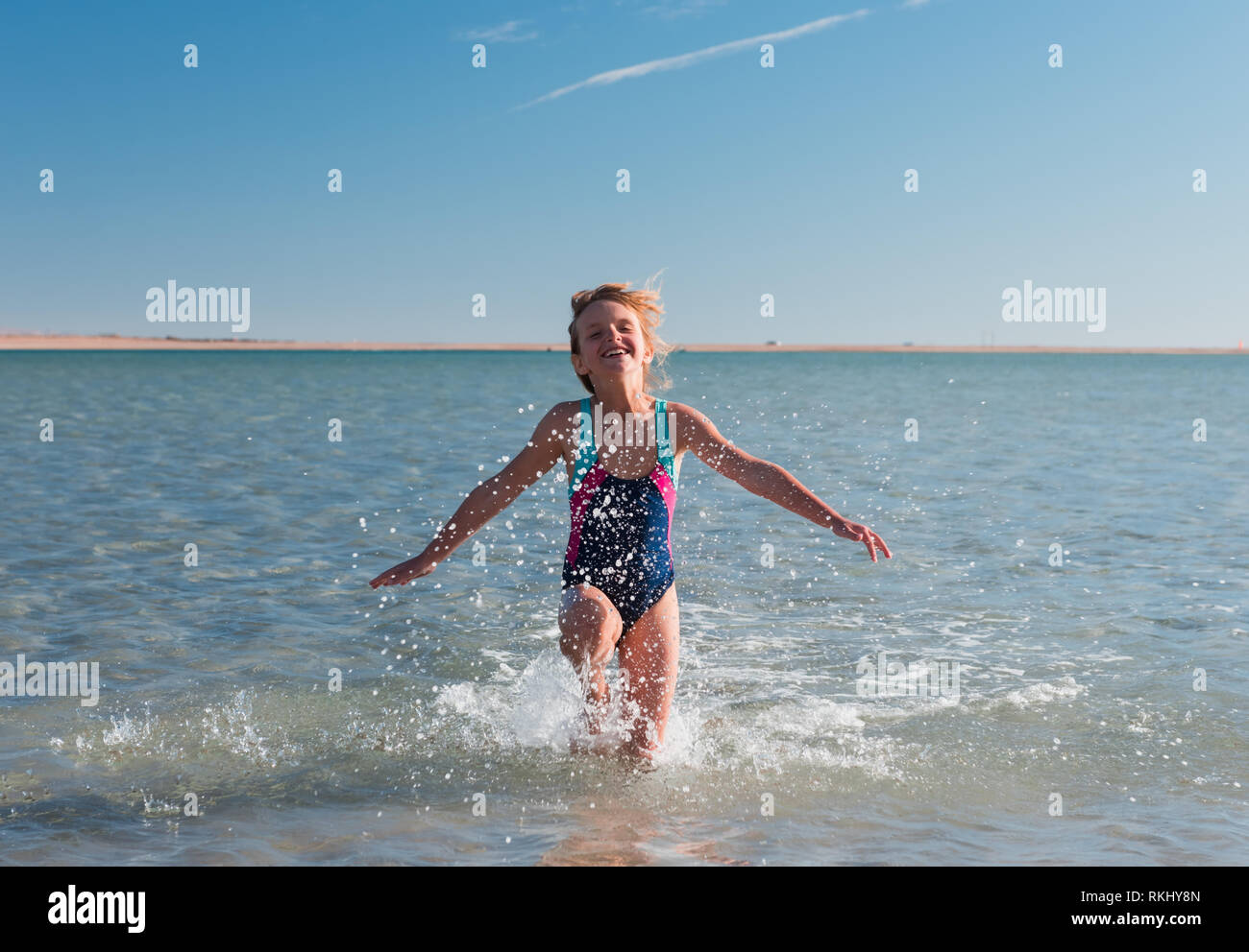 Kleine Mädchen spielen am schönen Strand. Glückliche Kindheit und Sport Stockfoto