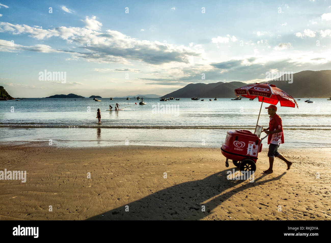 Strandverkäufer, der mit einem Eiswagen am Pantano do Sul Beach spazieren geht. Florianopolis, Santa Catarina, Brasilien. Stockfoto