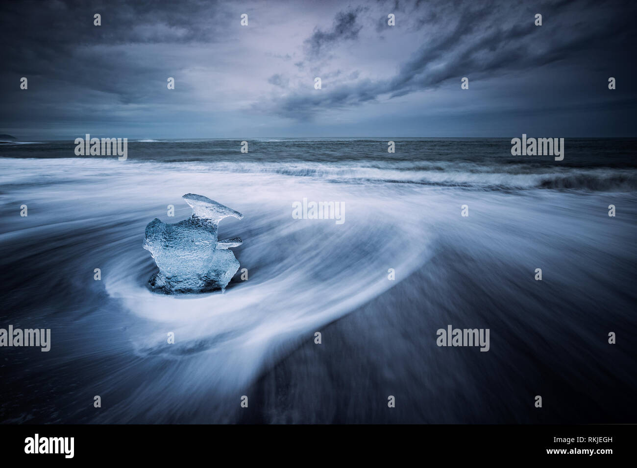 Meer driftet in um die Eisberge und das Gletschereis, die am Strand auf dem schwarzen Sand am Gletschersee Jökulsárlón, Island gefegt wird Stockfoto