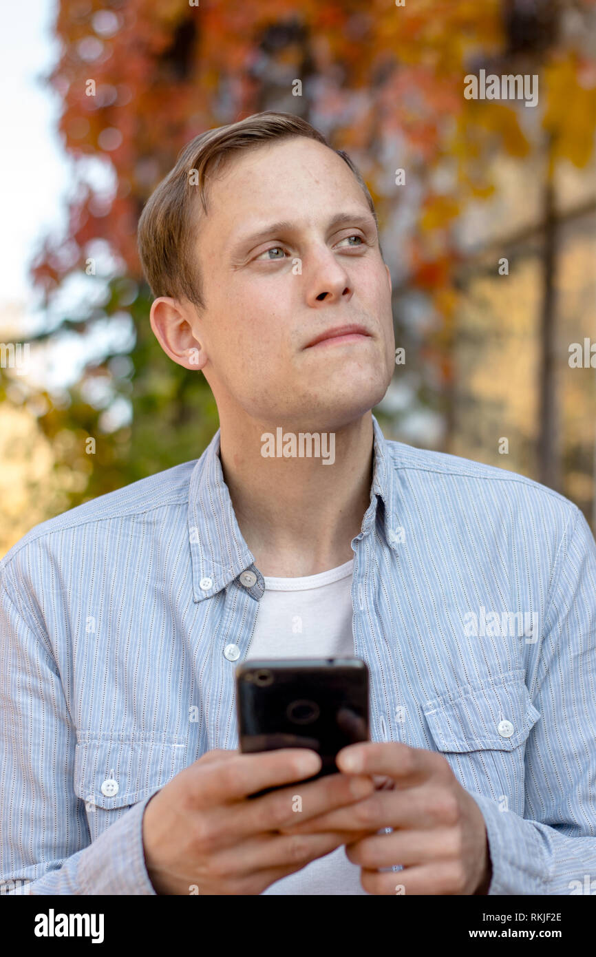 Portrait von Kerl mit einem Telefon in Freizeitkleidung Stockfoto