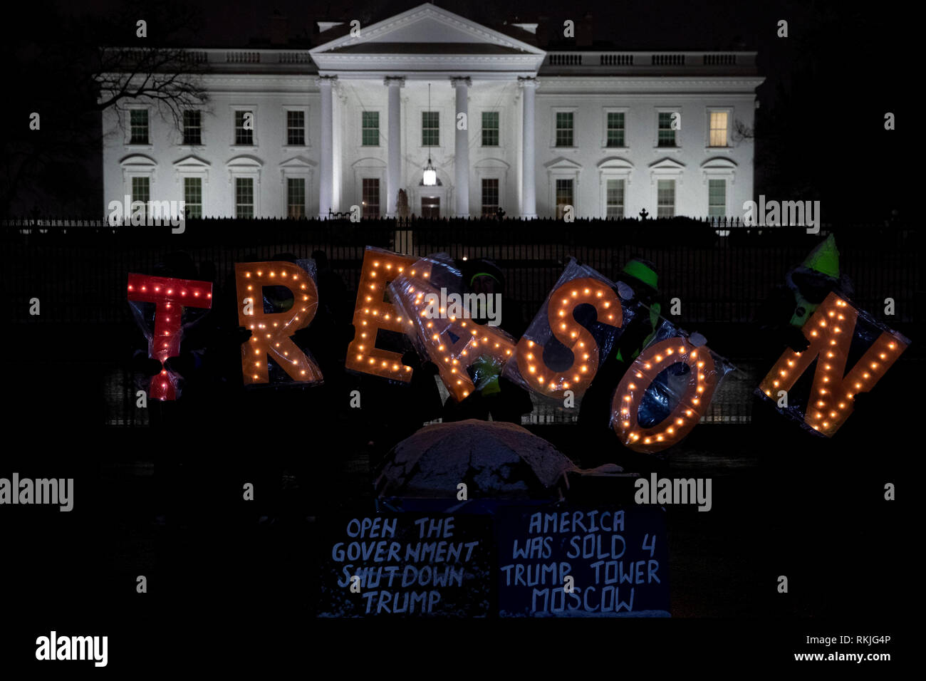 Die Demonstranten halten beleuchteten Buchstaben Anzeichen dafür, dass Lesen 'Verrat', während außerhalb des Weißen Hauses protestieren während des partiellen Regierung Abschaltung in Washington, D.C., USA, am Samstag, Jan. 12, 2019. Stockfoto