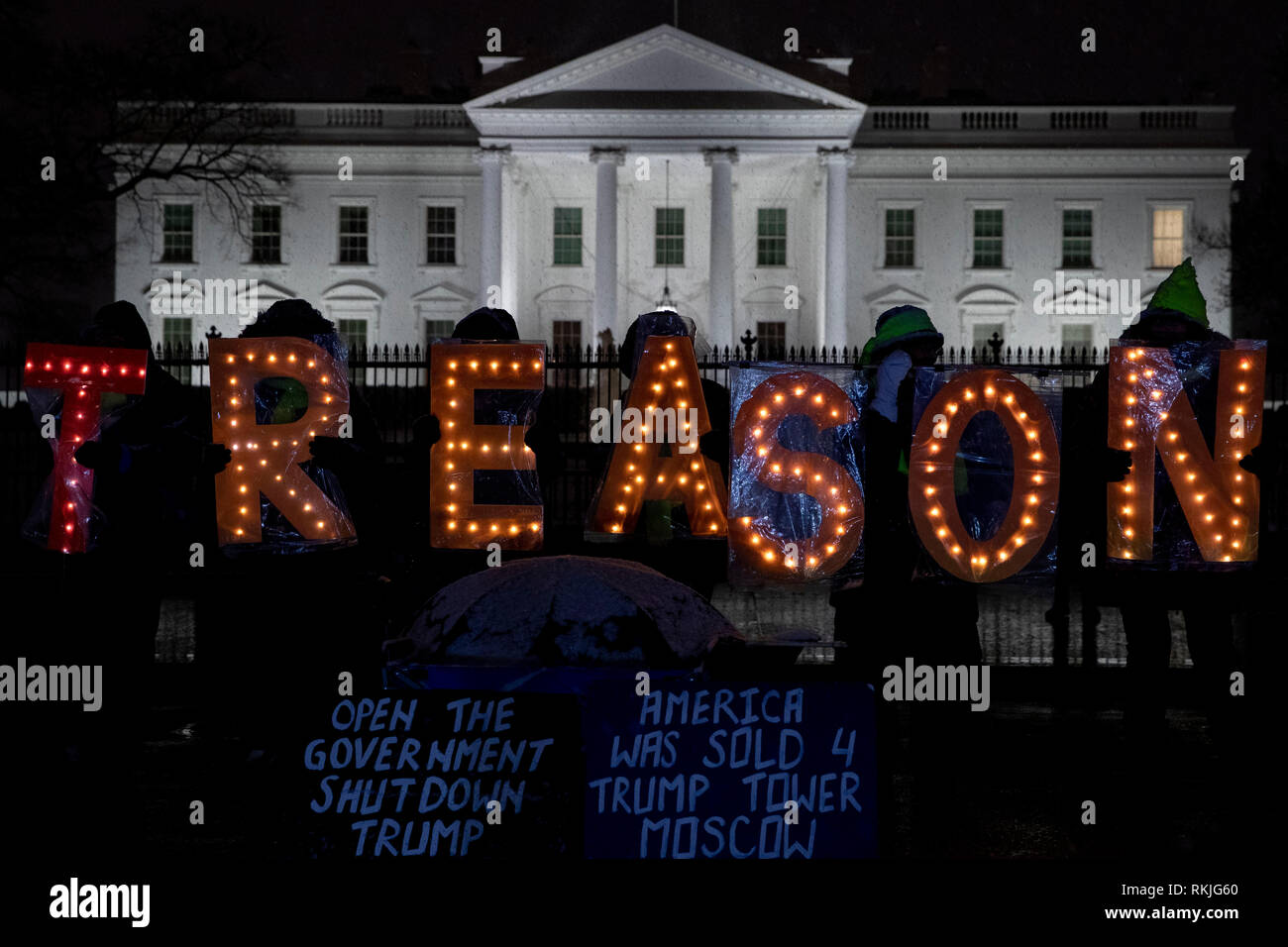 Die Demonstranten halten beleuchteten Buchstaben Anzeichen dafür, dass Lesen 'Verrat', während außerhalb des Weißen Hauses protestieren während des partiellen Regierung Abschaltung in Washington, D.C., USA, am Samstag, Jan. 12, 2019. Stockfoto