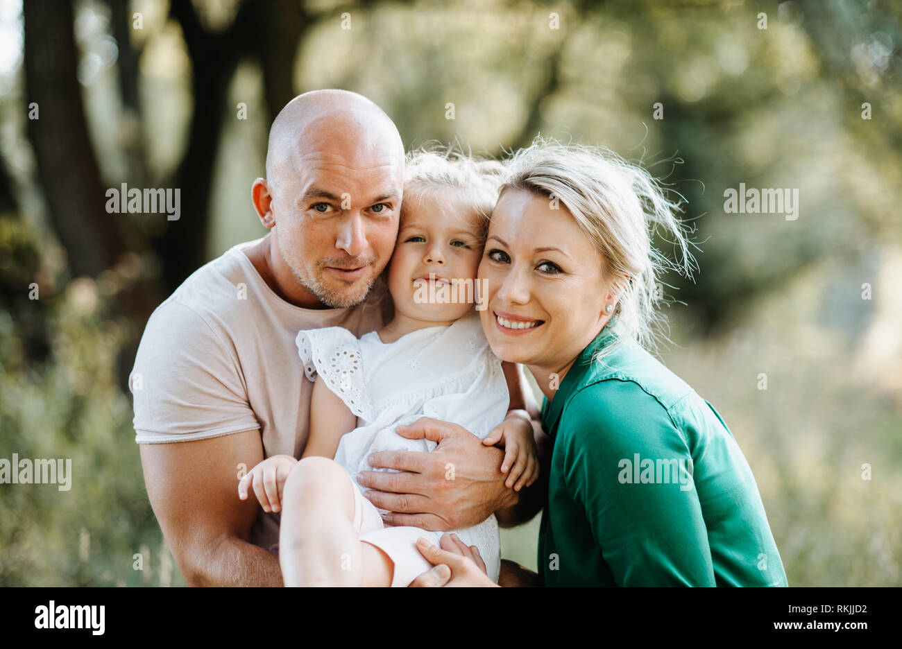Junge Familie mit einer kleinen Tochter im sonnigen Sommer Natur. Stockfoto