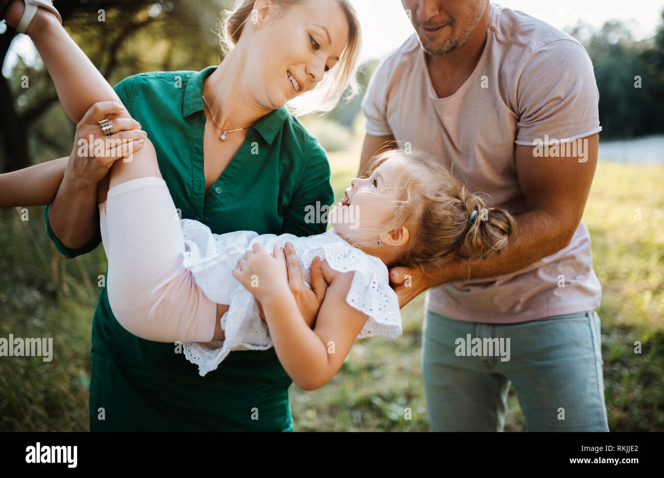 Junge Familie mit einer kleinen Tochter im sonnigen Sommer Natur, Spaß haben. Stockfoto