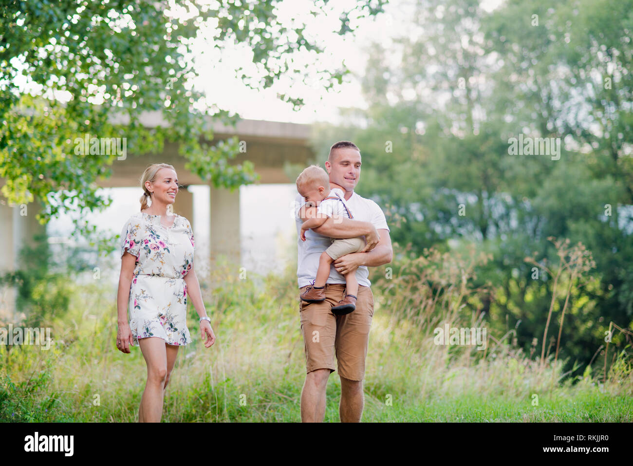 Junge Familie mit einem kleinen weinenden Kleinkind Junge im sonnigen Sommer Natur. Stockfoto