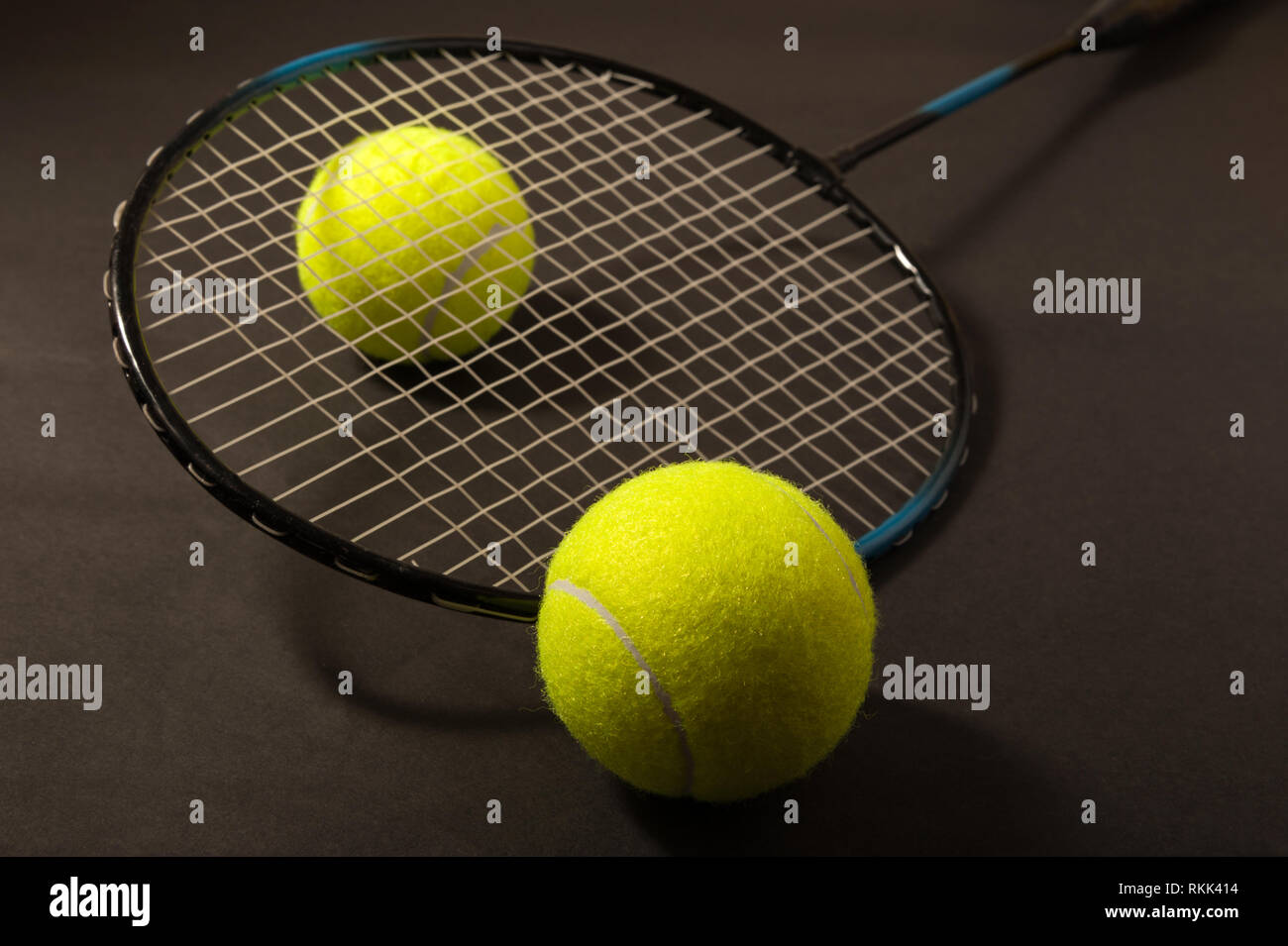Tennis Ball und Schläger auf dunklem Hintergrund Stockfoto