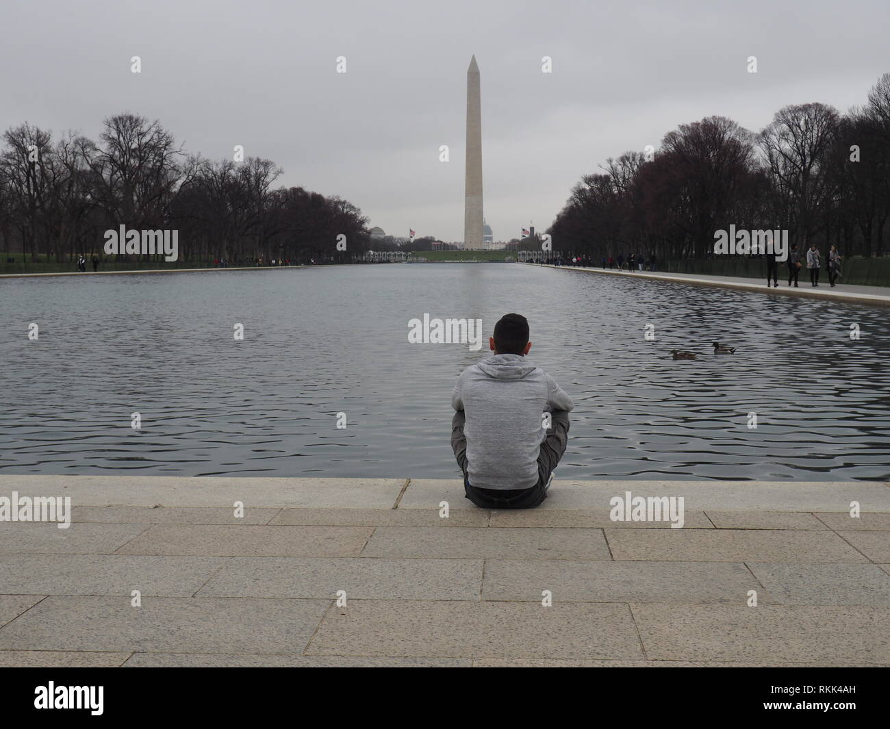 Mann Sitze durch die reflektierenden Pool am Lincoln Memorial in Washington DC, USA Stockfoto