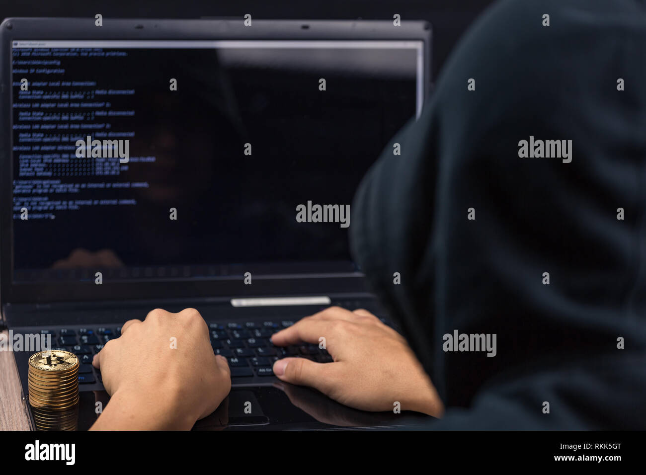 Gefährliche hooded Hacker auf Laptop bricht Computer Security sistem und stehlen Bitcoin cryptocurrency Stockfoto