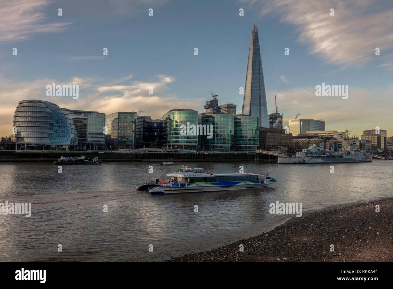 Am Flussufer in der Nähe der Themse in London. Morgen mit Sonne auf der Gebäude wider. Boot den Fluss übergeben. Stockfoto