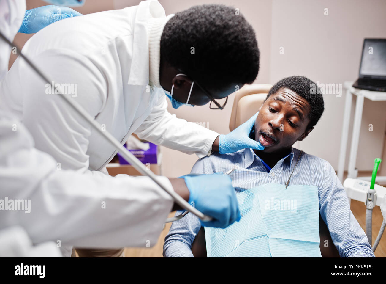 African American man Patient im Behandlungsstuhl. Zahnarzt und Arzt Praxis Konzept. Professionellen Zahnarzt seinen Patienten helfen bei der Zahnmedizin medica Stockfoto
