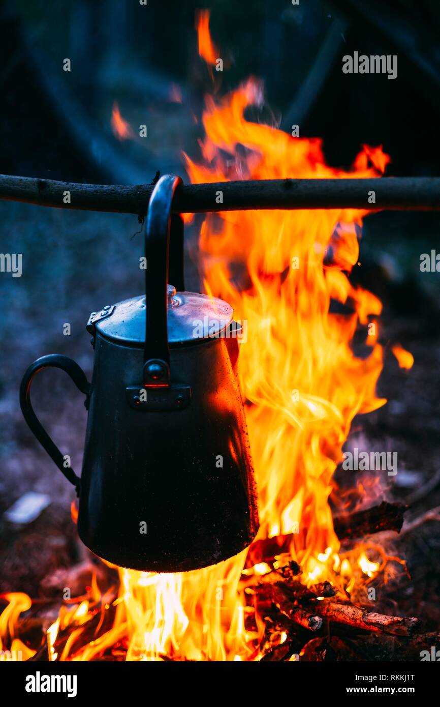 Altes Retro-Eisen Camp Wasserkocher kocht Wasser auf ein Feuer im Wald.  Helle Flamme Feuer Lagerfeuer in der Dämmerung Nacht Stockfotografie - Alamy