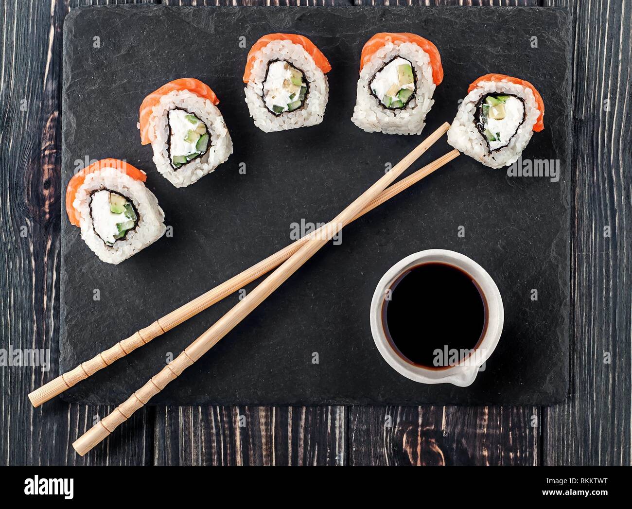 Philadelphia Sushi Roll auf schiefer Stein. Stäbchen mit Sojasauce in der  Nähe. Ansicht von oben Stockfotografie - Alamy