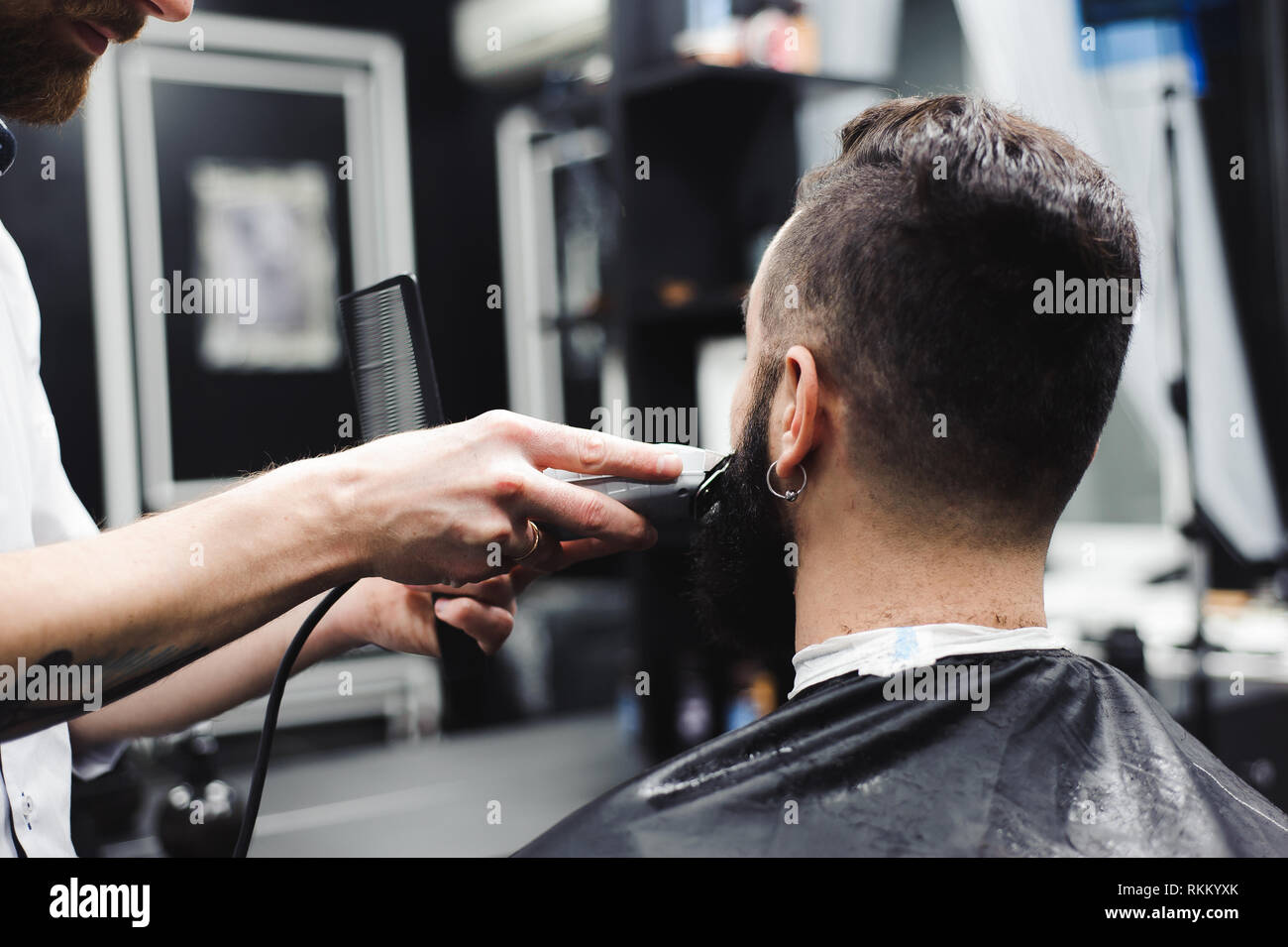 Junge schöne Friseur- und Abschlag von attraktiven Mann Stockfoto