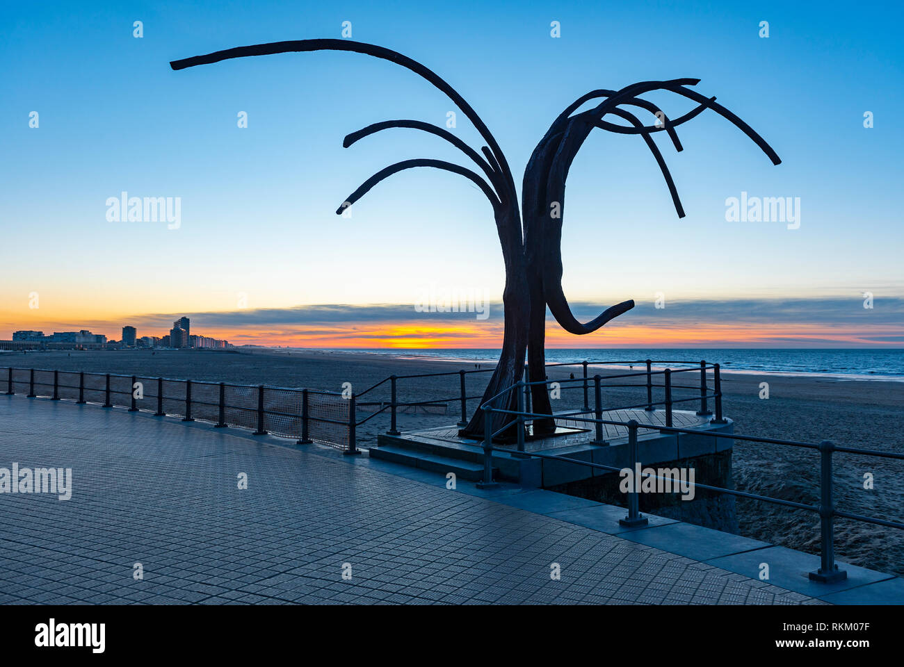 Die Waterfront von Oostende bei Sonnenuntergang mit Blick auf die Nordsee, die Skyline der Stadt und die Kunstwerke der Ancing 'Wellen', Westflandern, Belgien. Stockfoto