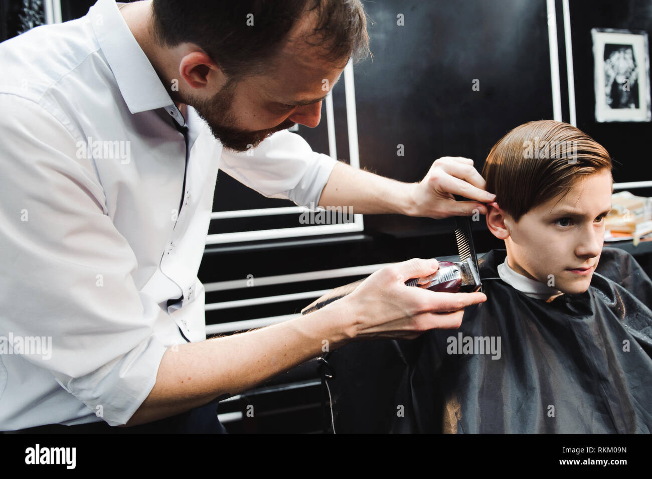 Süße Junge erhalten einen neuen Haarschnitt im Salon Stockfoto
