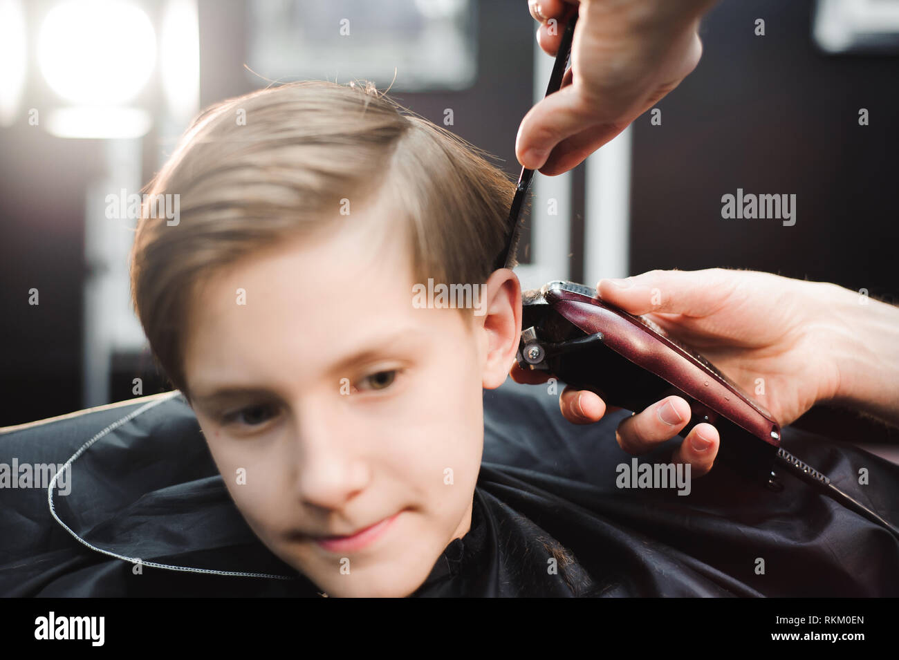 Süße Junge erhalten einen neuen Haarschnitt im Salon Stockfoto