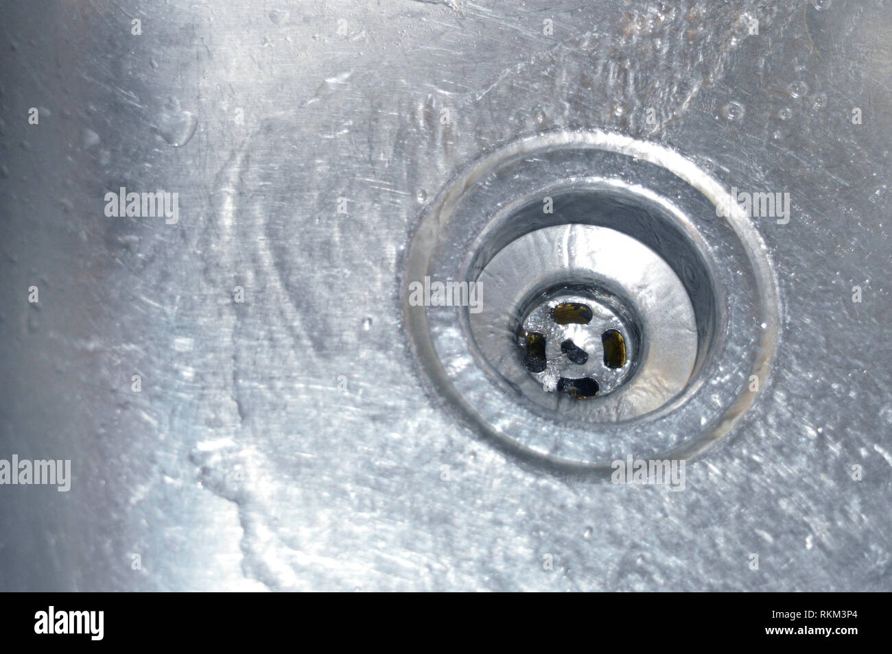 Sauberes, klares Wasser, das in einen Abfluss läuft Stockfoto