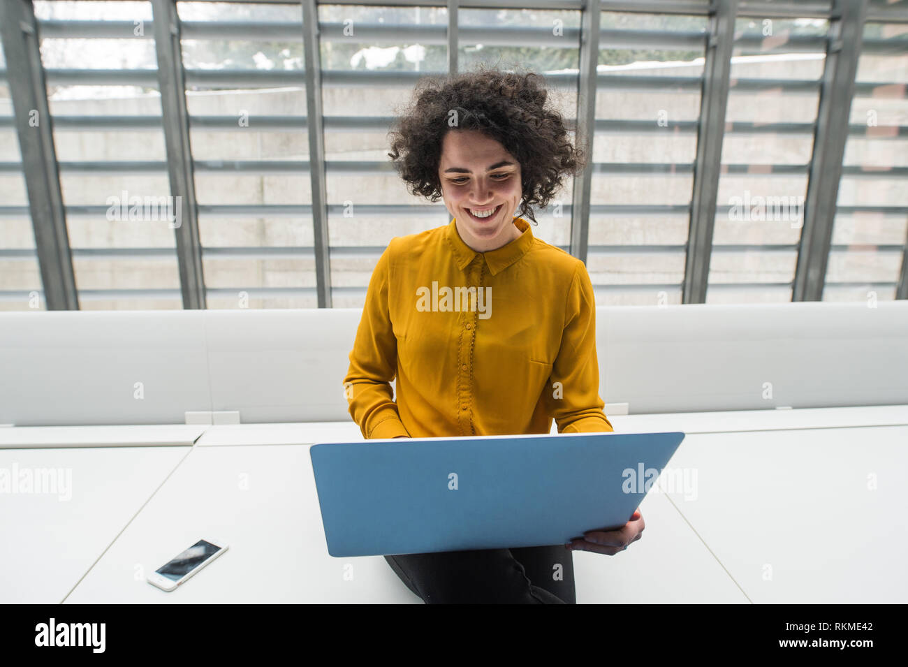 Junge student oder Geschäftsfrau, sitzen am Schreibtisch im Zimmer in einer Bibliothek oder einem Büro, mit Laptop. Stockfoto