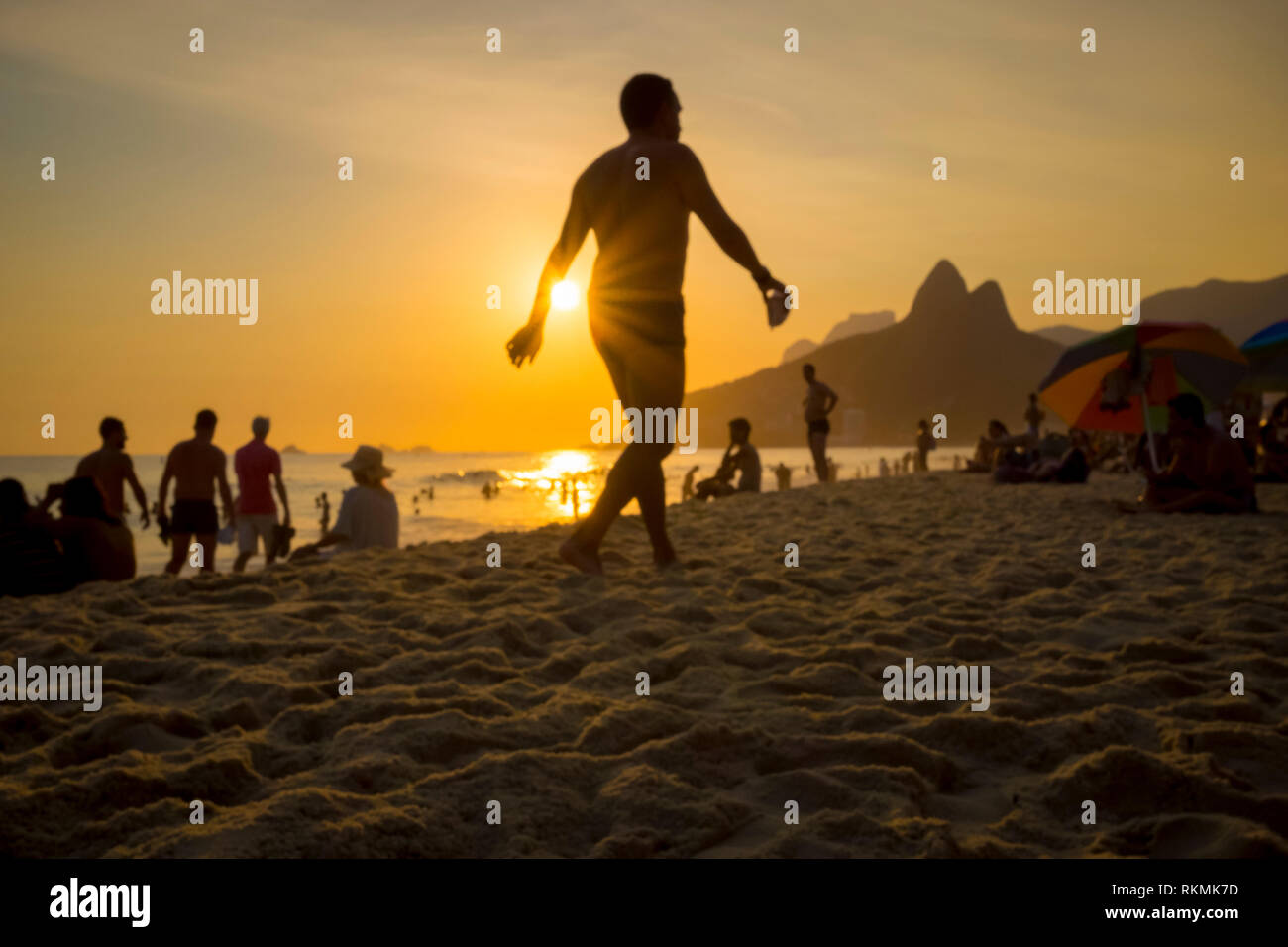 Beachgoers schlendern und an einem Sommernachmittag am Strand von Ipanema in Rio de Janeiro, Brasilien sozialisieren Stockfoto
