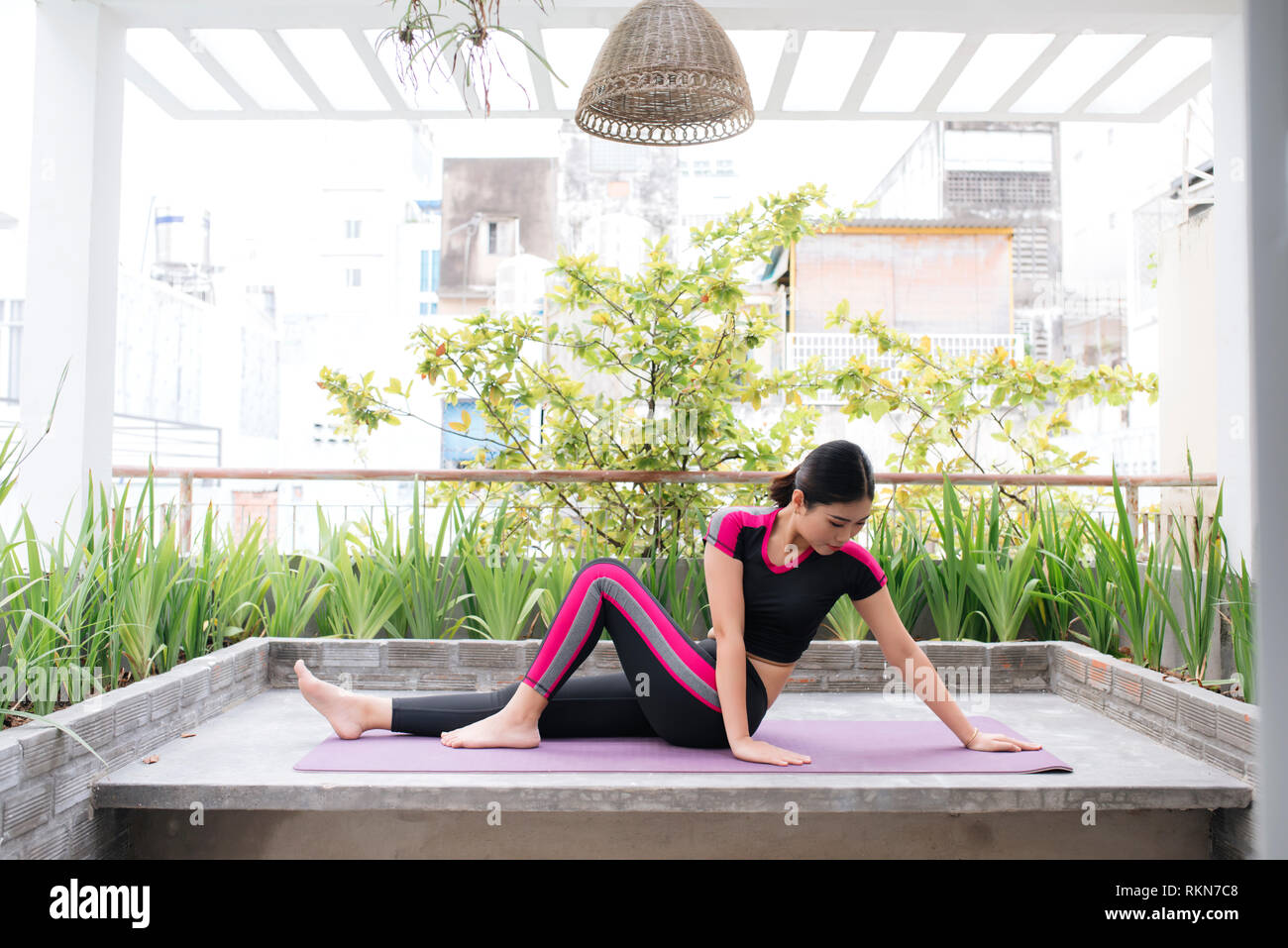 Junge asiatische Frau in Entspannung stretching Position auf Ihrem Balkon  Etage Stockfotografie - Alamy