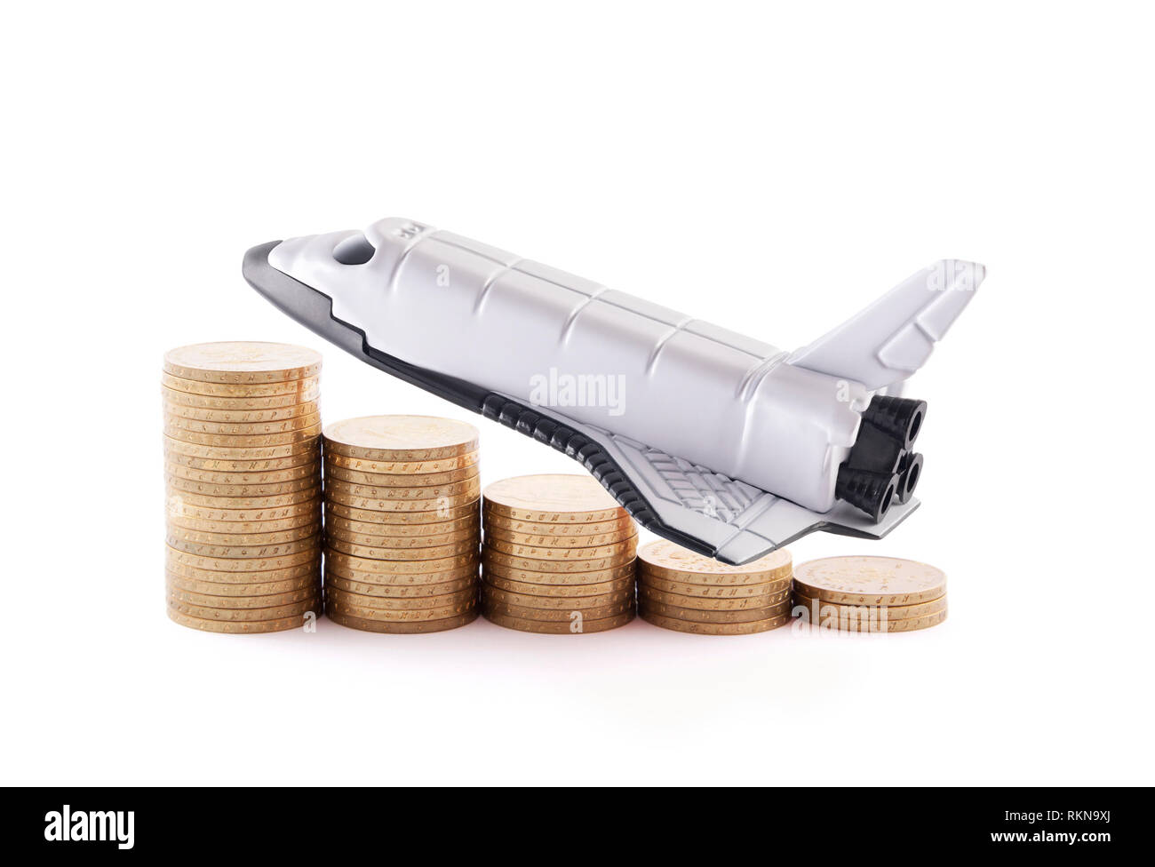 Space Shuttle mit steigenden Münzen auf weißem Hintergrund Stockfoto