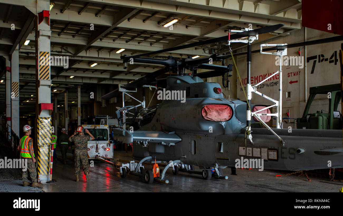 Us-Marines mit Marine Light Attack Helicopter Squadron 367 (HMLA-367) laden ein AH-1Z Viper auf ein Schiff an Bord Pearl Harbor, Hawaii, Feb 6, 2019. Die Flugzeuge werden auf einem Schiff für Ihre bevorstehenden Bereitstellung transportiert werden geladen. (U.S. Marine Corps Foto von Sgt. Ricky Gomez) Stockfoto