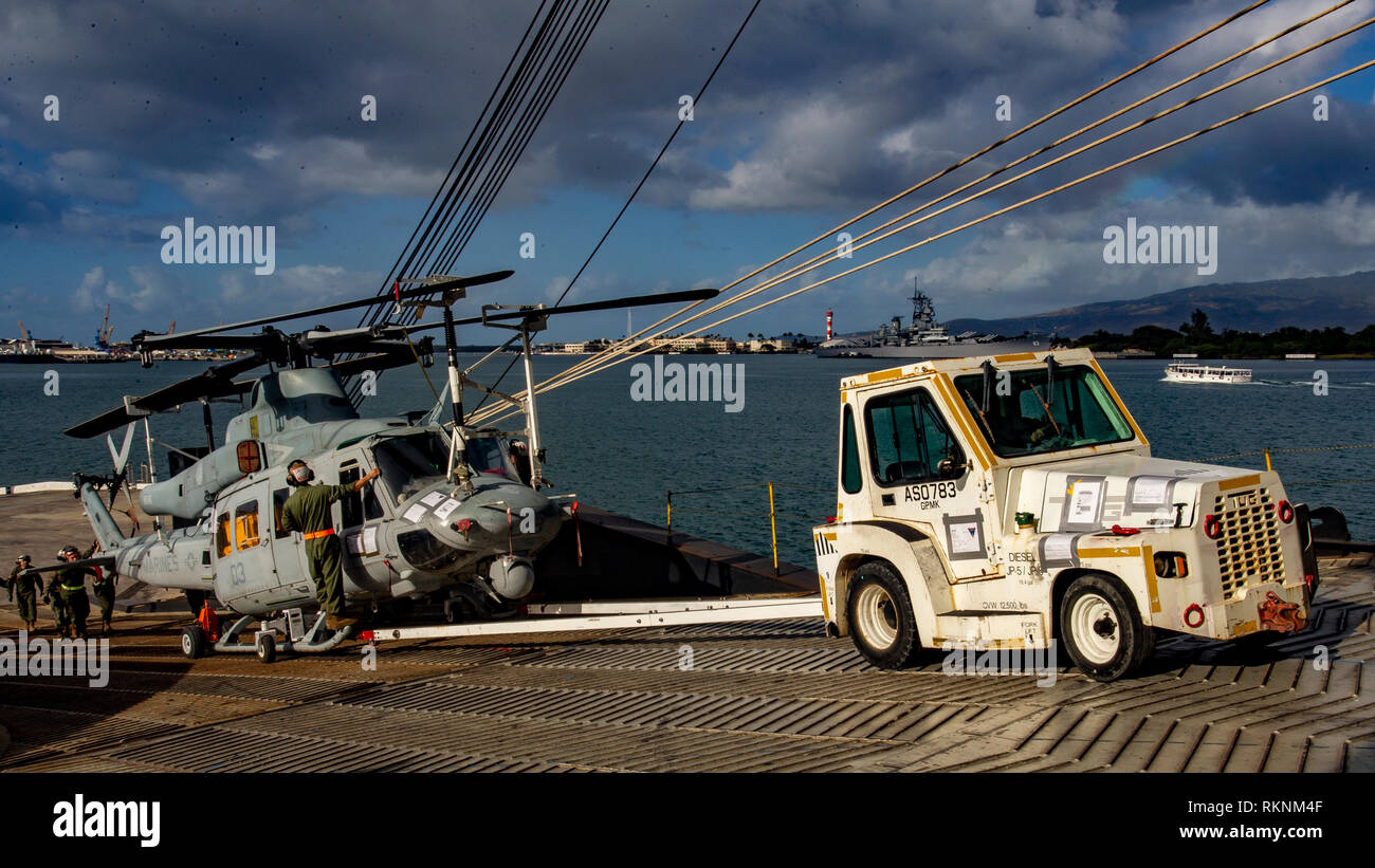 Us-Marines mit Marine Light Attack Helicopter Squadron 367 (HMLA-367) Ein UH-1Y Venom Last auf ein Schiff an Bord Pearl Harbor, Hawaii, Feb 6, 2019. Die Flugzeuge werden auf einem Schiff für Ihre bevorstehenden Bereitstellung transportiert werden geladen. (U.S. Marine Corps Foto von Sgt. Ricky Gomez) Stockfoto