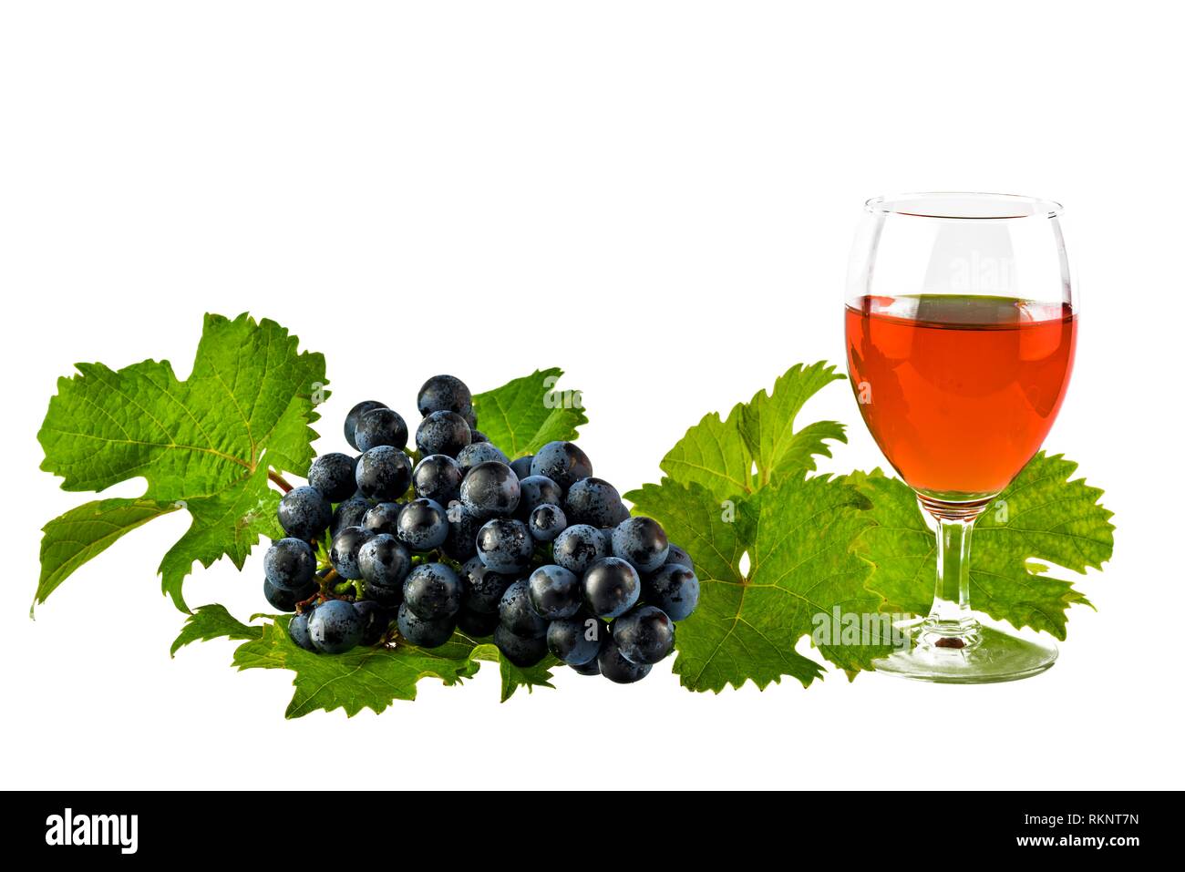 Rotwein mit roten Spitzen und Trauben isoliert auf weißem Stockfoto