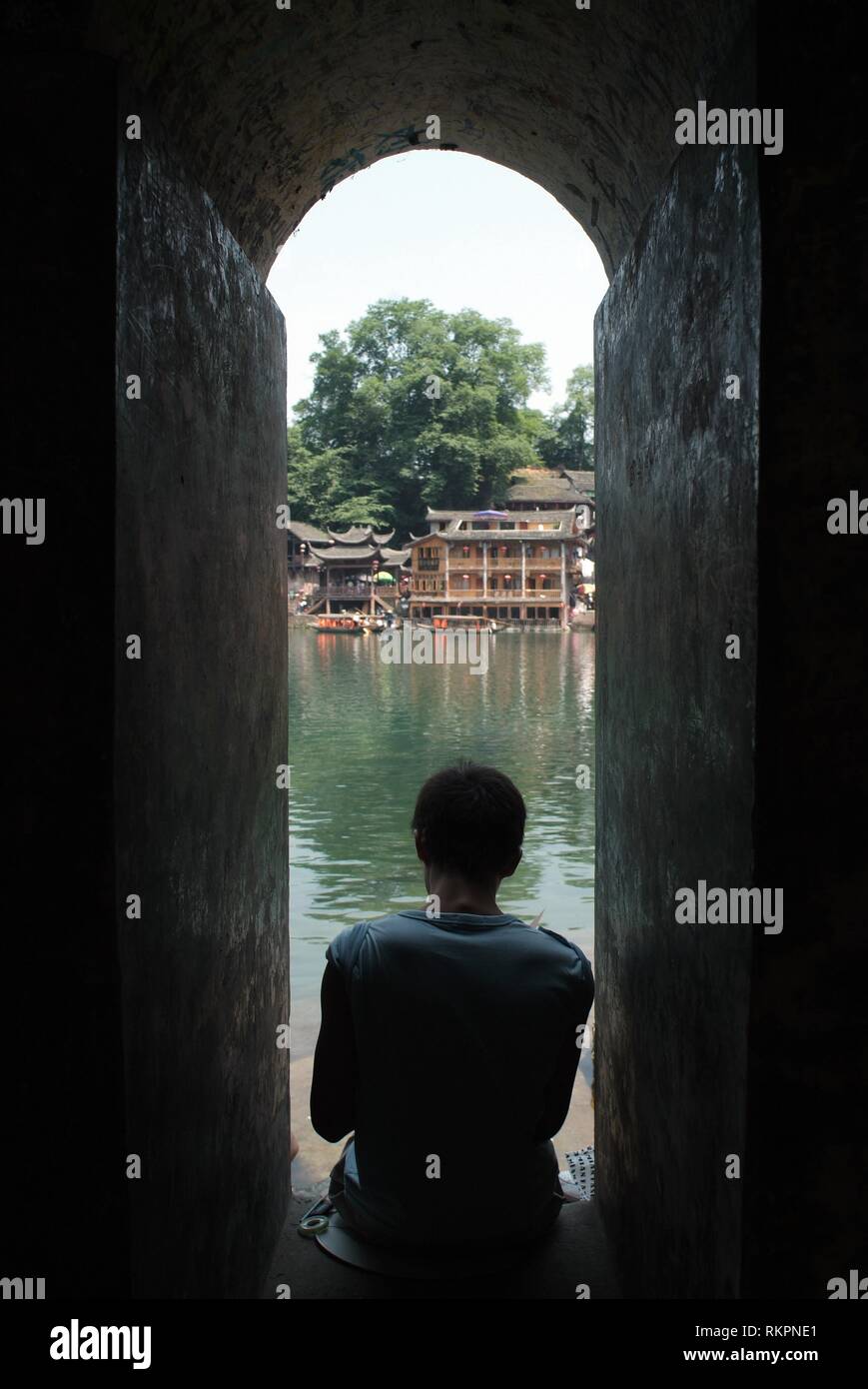 Ein Schüler skizziert Bilder der alten Häuser von Fenghuang. Stockfoto