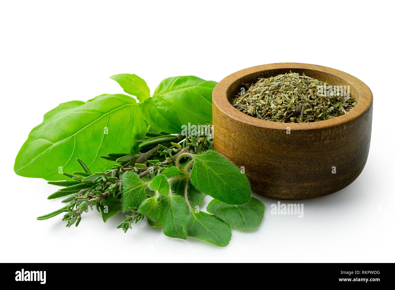 Getrocknete gehackte Provence Kräuter in einem dunklen Holz Schüssel neben frischen bouquet garni isoliert auf Weiss. Stockfoto