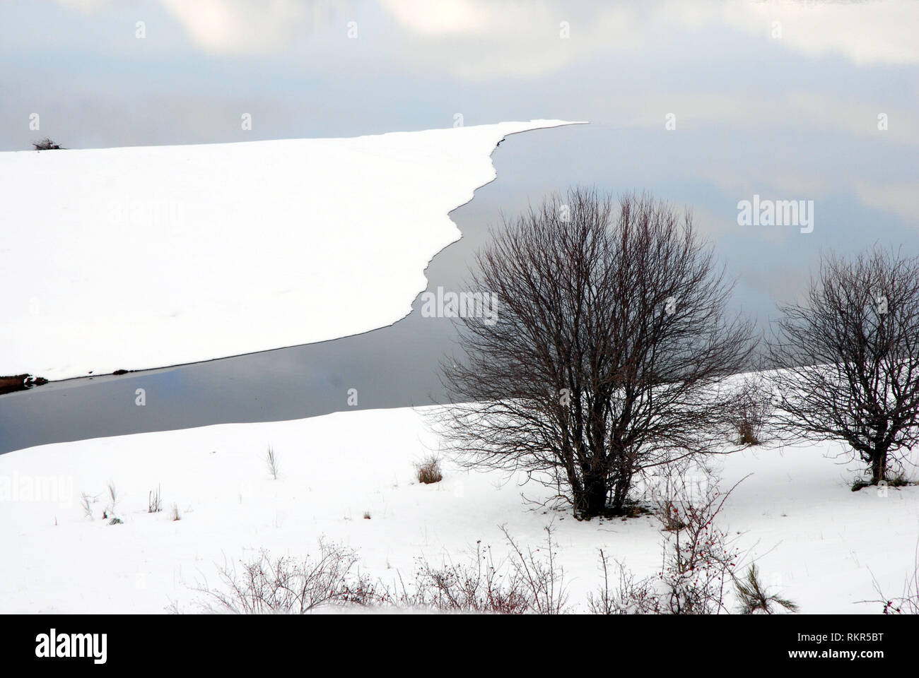 Kühlen Wasser des Sees mit dem Himmel im Winter Landschaft auf dem Berg von Sila Kalabrien verwirrt ist, Italien Stockfoto