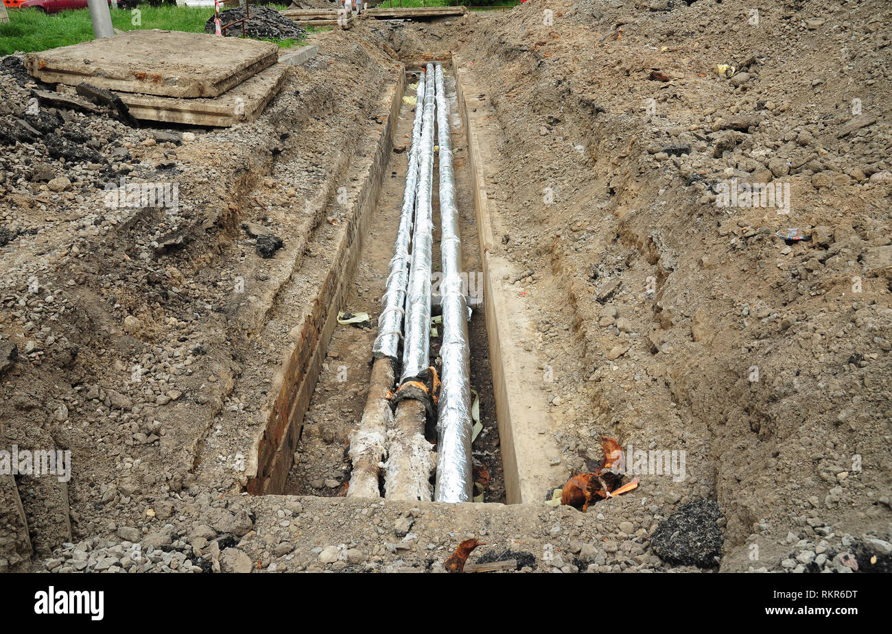 Installation und Isolation hot water Pipeline für Energieeinsparung und Energieeffizienz. Reparatur, Isolierung und Erneuerung der Kanalisation auf der Straße Stockfoto