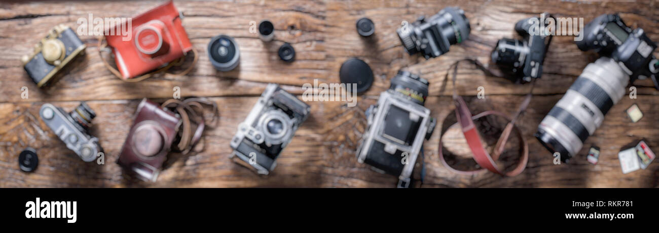 Verschwommen Panoramabild von verschiedenen Foto Kameras auf Holz- Hintergrund. Stockfoto