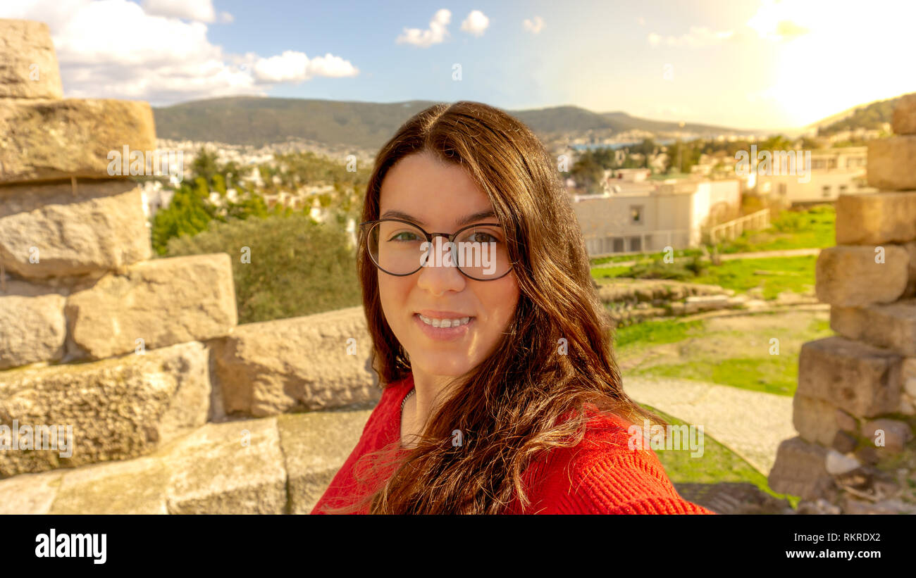 Porträt einer normalen Brünette junge Teenager hippie Brille und Zahnspange lächelnd und selfie. Reisen in Bodrum, Türkei. Stockfoto